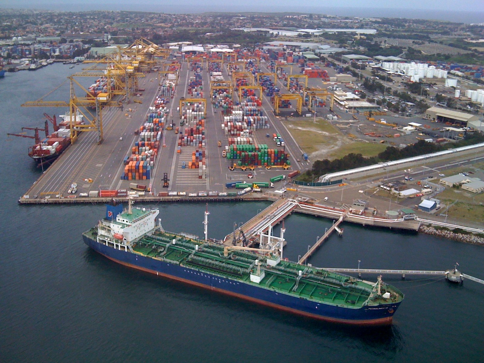 Container ship berthed at the Port of Melbourne with gantry cranes unloading, Australia