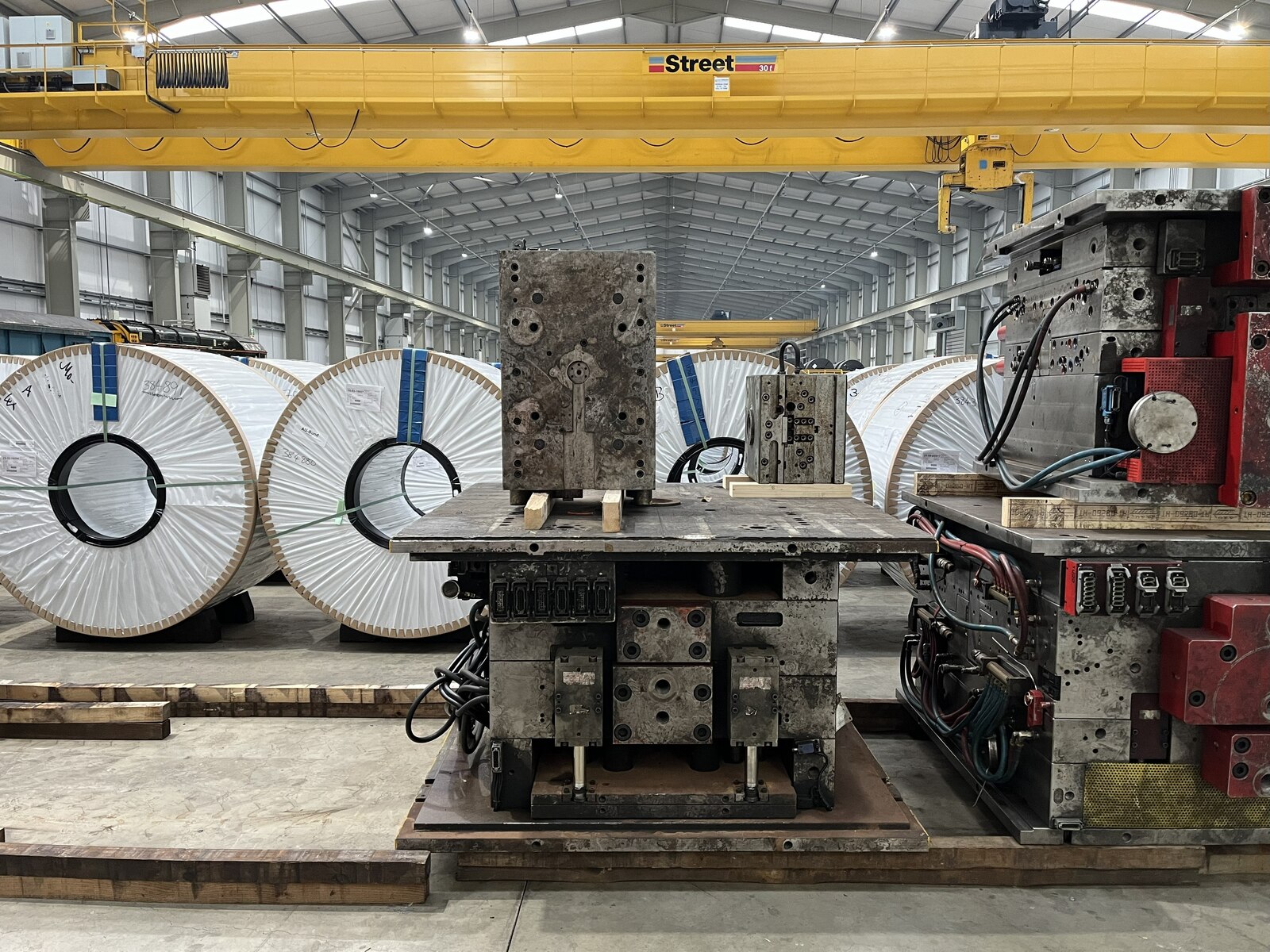 Coils of rolled steel stacked at a port warehouse awaiting import clearance